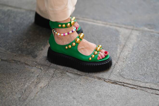 PARIS, FRANCE - MAY 10: Gabriella Berdugo wears beige high waist flared pants, green shiny leather with large gold studded / nailed dad shoes / sandals , during a street style fashion photo session, on May 10, 2022 in Paris, France. (Photo by Edward Berthelot/Getty Images)