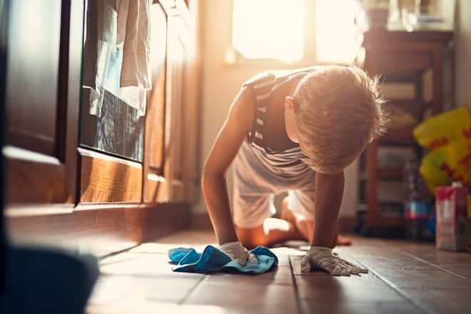 Little boy aged 8 cleaning floor.
