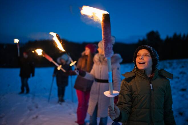 Familie spaziert mit Fackeln