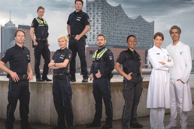 v.li.: Mattes Seeler (Matthias Schloo), Franzi Jung (Rhea Harder-Vennewald), Melanie Hansen (Sanna Englund), Nick Brandt (Raúl Richter), Kris Freiberg (Marc Barthel), Daisy Petersen (Aysha Joy Samuel), Dr. Jasmin Jonas (Gerit Kling) und Dr. Lazar Sharif (Atheer Adel) stehen für "Notruf Hafenkante" vor der Kamera.