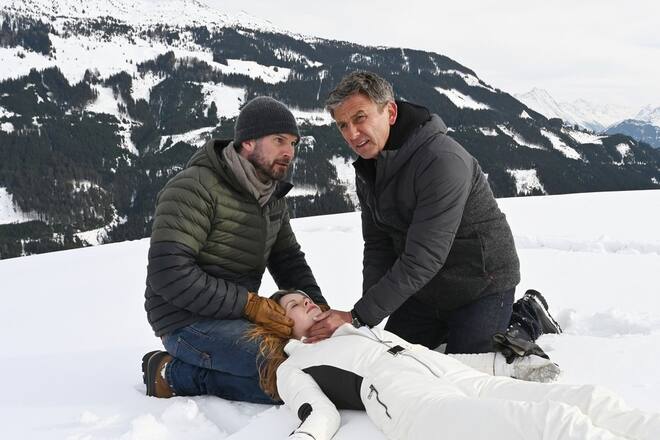 «Der Bergdoktor: Die dunkle Seite des Lichts»: Natalie (Emilie Bernsdorf) liegt bewusstlos im Schnee. Ihr Vater Hannes (Simon Böer, li.) und Dr. Martin Gruber (Hans Sigl) kümmern sich um sie.