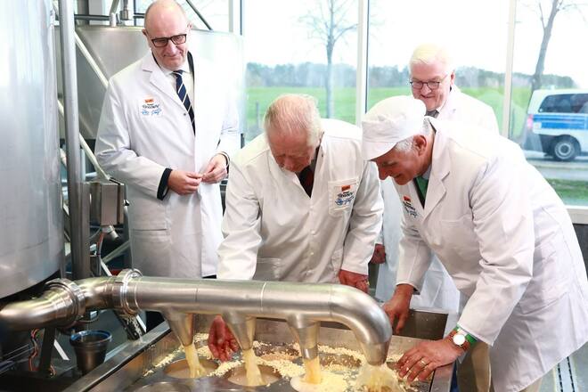 König Charles III. (2.v.l.) und Bundespräsident Frank-Walter Steinmeier (hinten) machen Käse in einem Ökodorf.