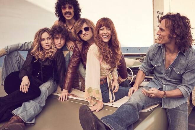 Riley Keough (zw. v. r.) und Sam Claflin (r.) spielen die beiden Hauptrollen Daisy Jones und Billy Dunne.