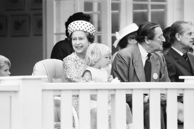 Three year old Zara Phillips, daughter of Princess Anne and Captain Mark Phillips, pictured attending the polo match at Smith's Lawn Polo Ground in Windsor, here she is pictured sitting on the lap of her grandmother, Queen Elizabeth II, in the Royal Box, 17th June 1984. (Photo by Alisdair MacDonald/Daily Mirror/Mirrorpix/Getty Images)