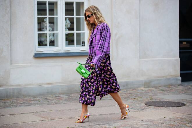 COPENHAGEN, DENMARK - AUGUST 11: Emili Sindlev seen wearing checkered purple cropped blazer, skirt with slit and floral print, green Fendi bag outside Baum und Pferdgarten during Copenhagen Fashion Week Spring/Summer 2021 on August 11, 2020 in Copenhagen, Denmark. (Photo by Christian Vierig/Getty Images)