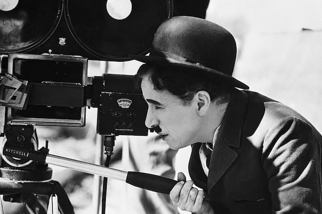 Actor Charlie Chaplin looks though a movie camera on April 22, 1935. He is directing, as well as acting in, a comedy tentatively titled Production No. 5.