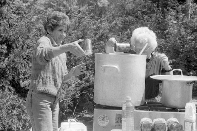 two woman working in an outdoor kitchen