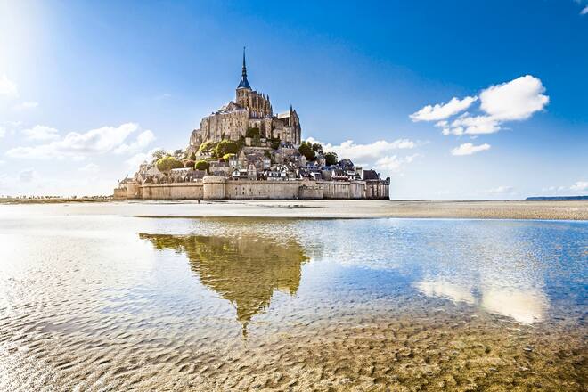 Panoramic view of famous Le Mont Saint-Michel tidal island on a sunny day with blue sky and clouds, Normandy, northern France. Excellence Royal: Das Beste, frisch aus dem Meer | Reisebüro Mittelthurgau Fluss und Kreuzfahrten AG