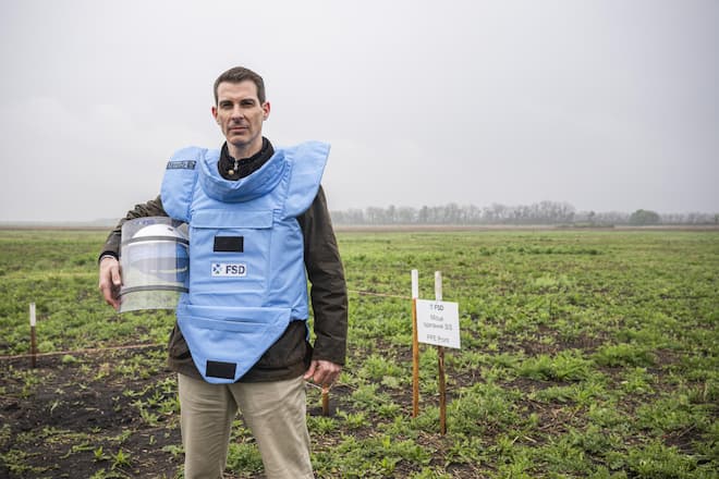 FDP-Chef Thierry Burkart im hellblauen Splitterschutz. Er besucht ein Feld im Osten der Ukraine, auf dem die Schweizer Organisation FSD Minen räumt.