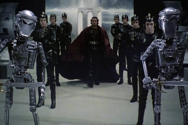 a scene with people in black and two robots