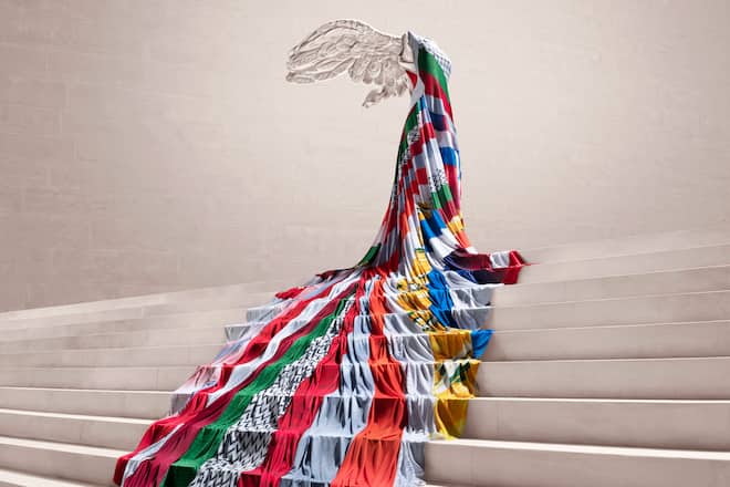 Victoire de Samothrace, habillée d'une robe de 7 mètres constituée de bandes de drapeaux, réalisée par Koché et Nike pour la Coupe du Monde de Football Féminine – 2019