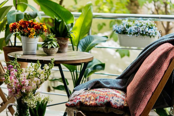 Mit blühenden Pflanzen, gemütlichen Kissen und kuscheligen Decken wird der Balkon zur Sommer-Oase.