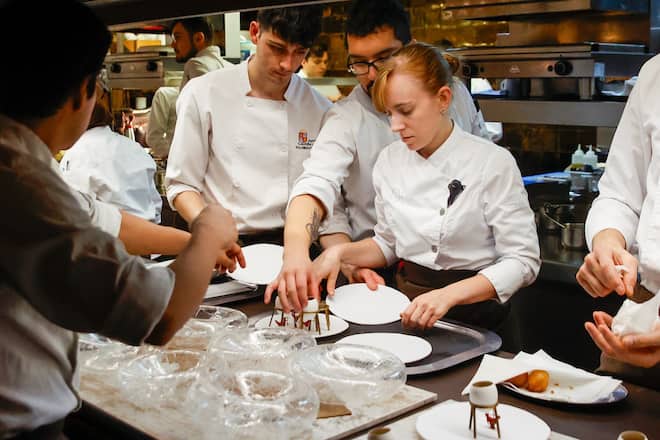 Mitarbeiterinnen und Mitarbeiter im Disfrutar, dem besten Restaurant der Welt, bereiten Speisen zu.