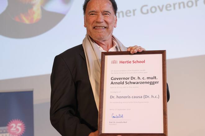 Arnold Schwarzenegger präsentiert stolz seinen Doktortitel in Berlin.