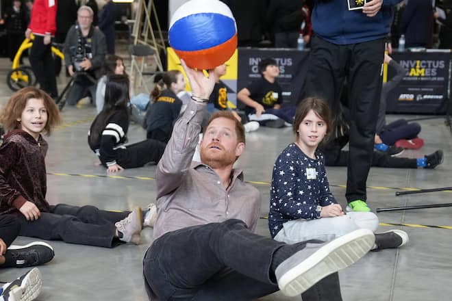 So geht's: Prinz Harry machte den Kindern vor, wie man Sitzvolleyball spielt.