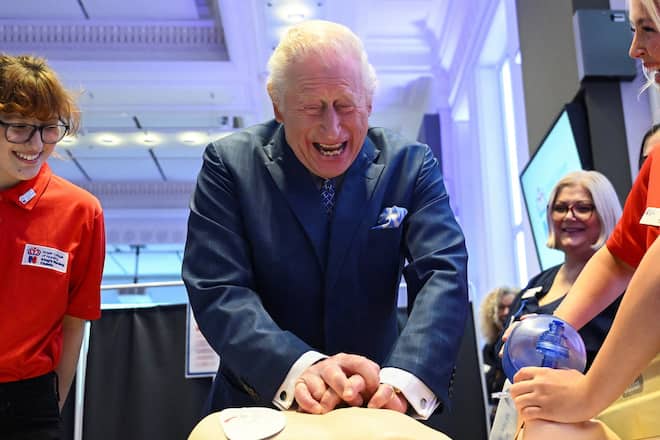 König Charles bearbeitet eine Trainingspuppe.