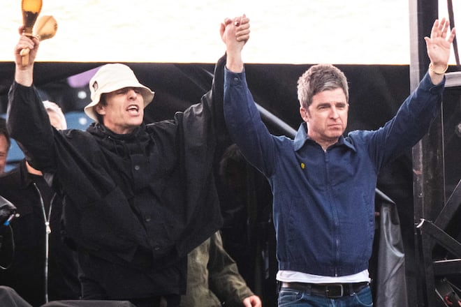 Liam und Noel Gallagher triumphierend auf der Bühne.
