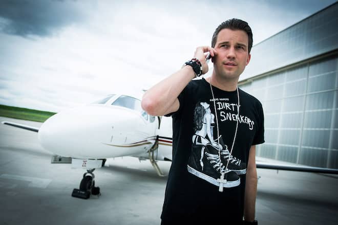 DJ Antoine telefoniert vor dem Privatjet am Flughafen Basel