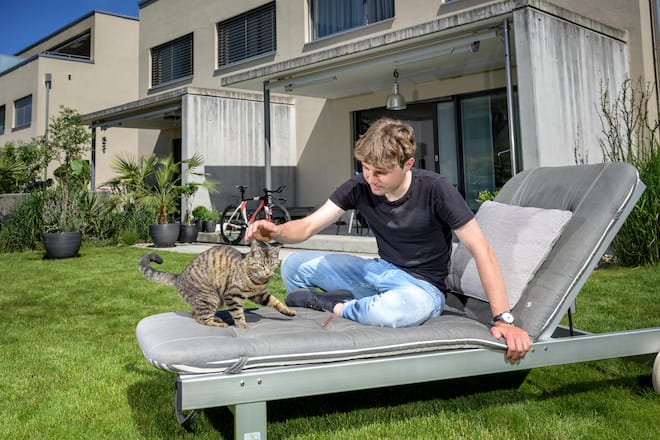 Marc Hirschi, U23-Weltmeister im Radfahren, steht vor seiner ersten Tour de Suisse, ausruhen mit Katze Mira im Garten. Aufgenommen in Ittigen. Bild © Remo Naegeli