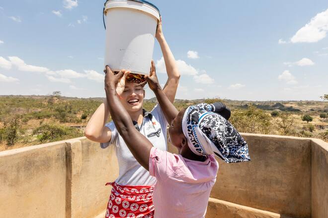 SRK Manuela Frey bei Alice Chanza. Manuela macht sich ein Bild über die Erfolge der WASH-Kampagne und hilft im Alltag mit. Ort: Alufeyo Mbale Village, Malawi. Foto: Bernard van Dierendonck