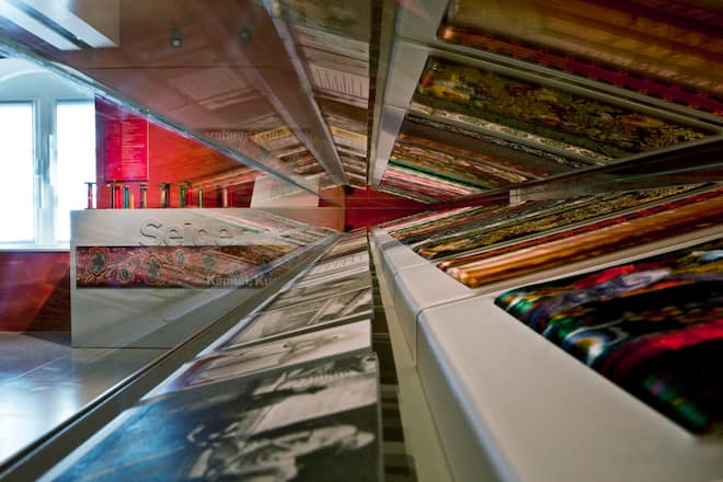 Leuchtende Seidenbänder als glanzvolle Zeugnisse vergangener Handwerkskunst im Museum.