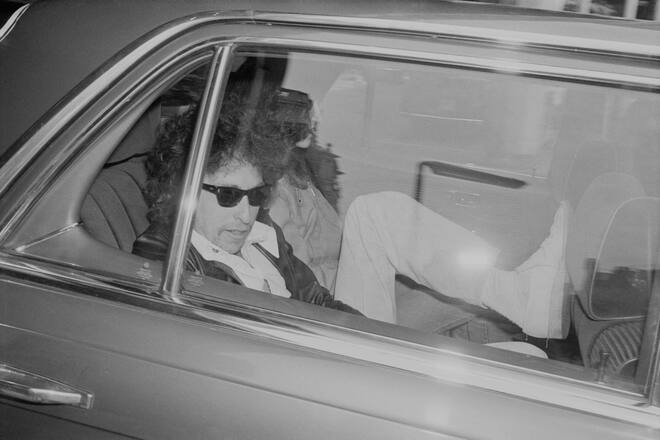 American singer-songwriter, author, and painter Bob Dylan sitting inside a car while travelling to Earls Court, UK, London, 15th June 1978. (Photo by Evening Standard/Hulton Archive/Getty Images)