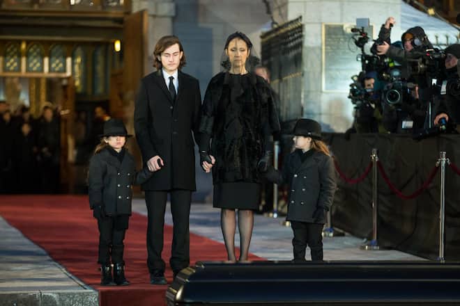 TOPSHOT - Céline Dion and her sons René-Charle, 15, Eddy and Nelson, 5, pause as the casket of her late husband René Angélil is carried to a waiting hearse following his funeral service at Notre-Dame Basilica in Montreal on January 22, 2016. Thousands of people were expected Friday at the funeral Angelil. The funeral mass is to be televised live across Canada and streamed worldwide for the singer's fans around the world. (Photo by Geoff Robins / AFP) (Photo by GEOFF ROBINS/AFP via Getty Images)