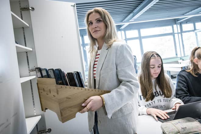 <p>Klassenlehrerin Nadine Schindler versorgt die «Handy-Garage» in einem Schrank.</p>